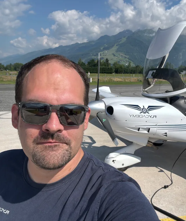 Christian Kirsch am Flugplatz vor einem einmotorigen Flugzeug